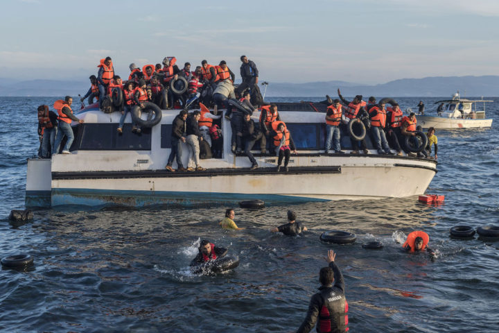 Refugiados sirios e iraquíes tratan de desembarcar en las aguas costeras de Lesbos en Grecia, después de haber cruzado desde Turquía. 2015