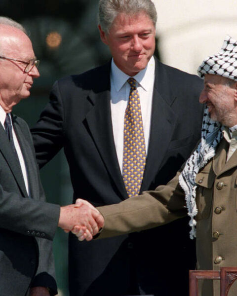 El Presidente de EE.UU. Bill Clinton (C) se encuentra entre el líder de la OLP Yasser Arafat (D) y el Primer Ministro israelí Yitzahk Rabin (I) mientras se dan la mano por primera vez, el 13 de septiembre de 1993 en la Casa Blanca en Washington DC, después de firmar los Acuerdos de Oslo Israel-OLP sobre la autonomía palestina en los territorios ocupados. / FOTO AFP / J. DAVID AKE