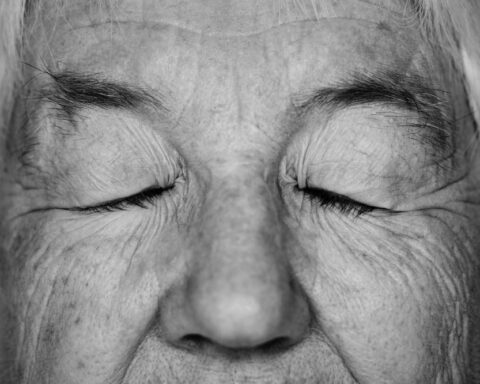 Rostro de una anciana con los ojos cerrados, foto en blanco y negro.