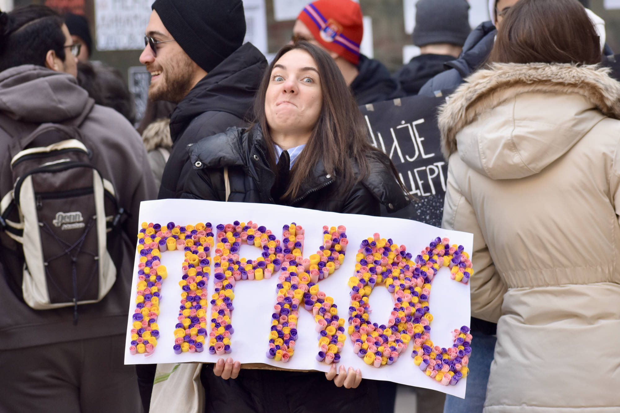 Joven sostiene un cartel con la palabra "Prkos" (desafío, resistencia, orgullo desafiante), en la manifestación del 5 de febrero de 2025. Foto: Arocha, 2025.