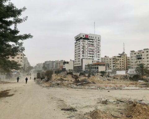 Dos personas caminan en medio de la destrucción de la franja de Gaza.