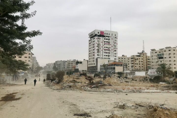 Dos personas caminan en medio de la destrucción de la franja de Gaza.