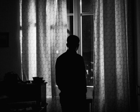 Un hombre mira a través de una ventana