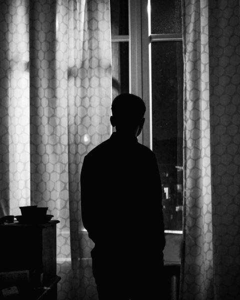 Un hombre mira a través de una ventana