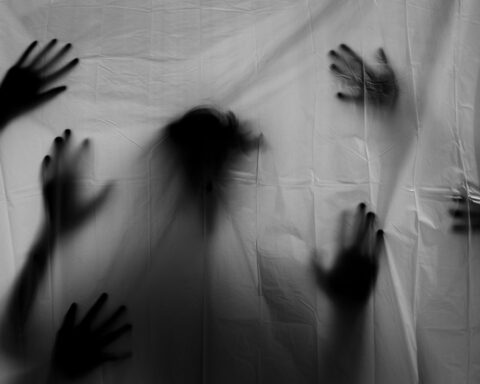 Figuras y sombras detrás de sábana blanca que representan el miedo