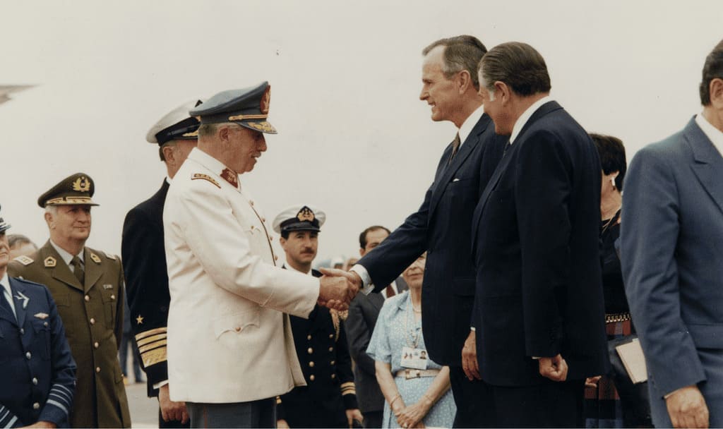 Representación de la política intervencionista estadounidense mediante fotografía de Bush y Pinochet.